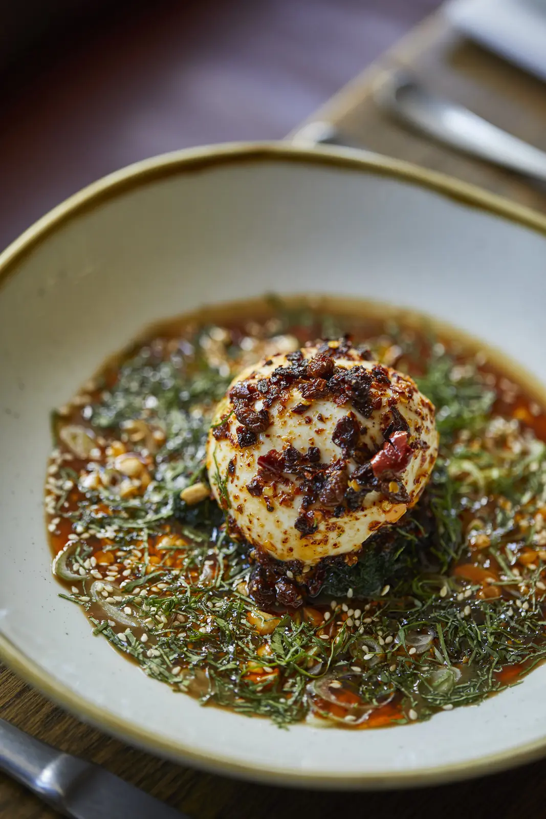 A dish of burrata with herbs and chilli oil